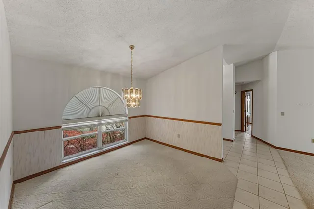 an empty room with a ceiling fan and a window