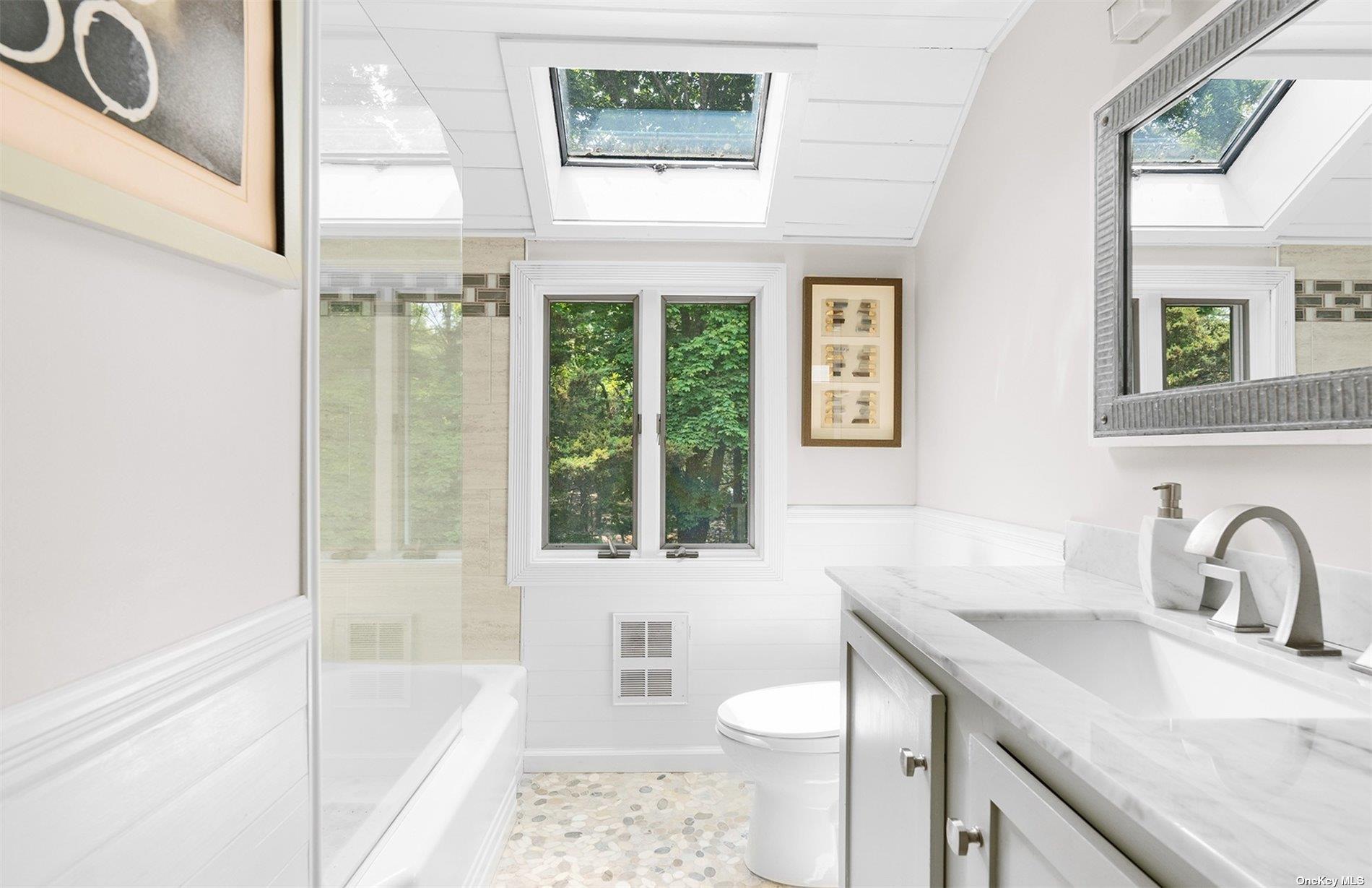 61 Lower 7 Ponds Road Water Mill, NY 11976 - Photo 28 of 43 a bathroom with a sink toilet a mirror and bathtub