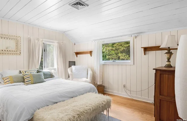 a bedroom with a bed and a mirror on the dresser