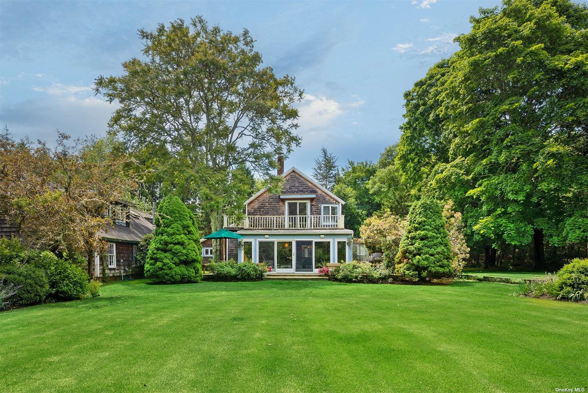 61 Lower 7 Ponds Road Water Mill, NY 11976 - Photo 3 of 43 a front view of a house with a garden