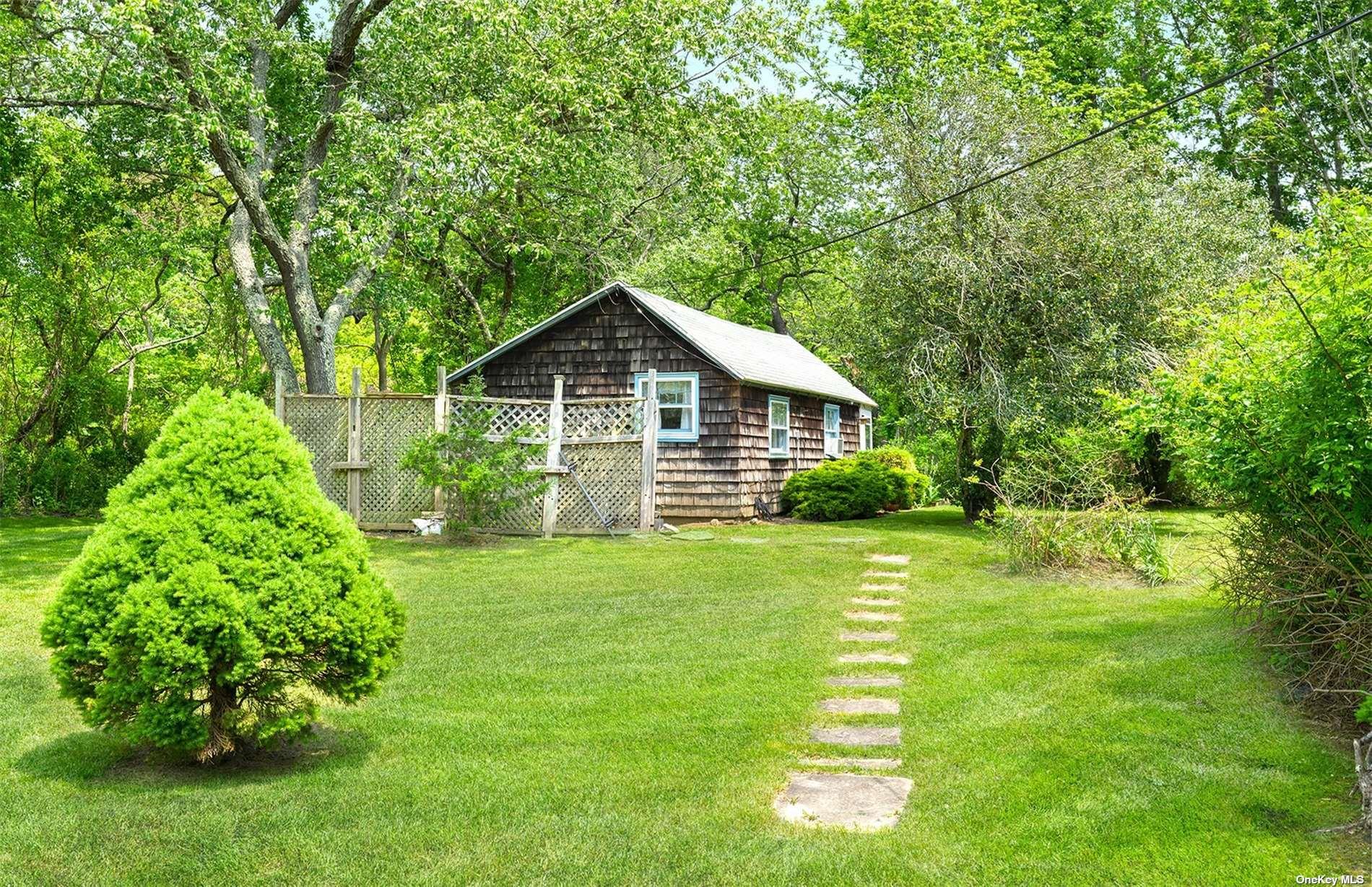 61 Lower 7 Ponds Road Water Mill, NY 11976 - Photo 38 of 43 a front view of a house with a yard