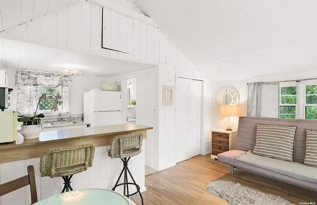 a kitchen with stainless steel appliances a white table chairs and a refrigerator