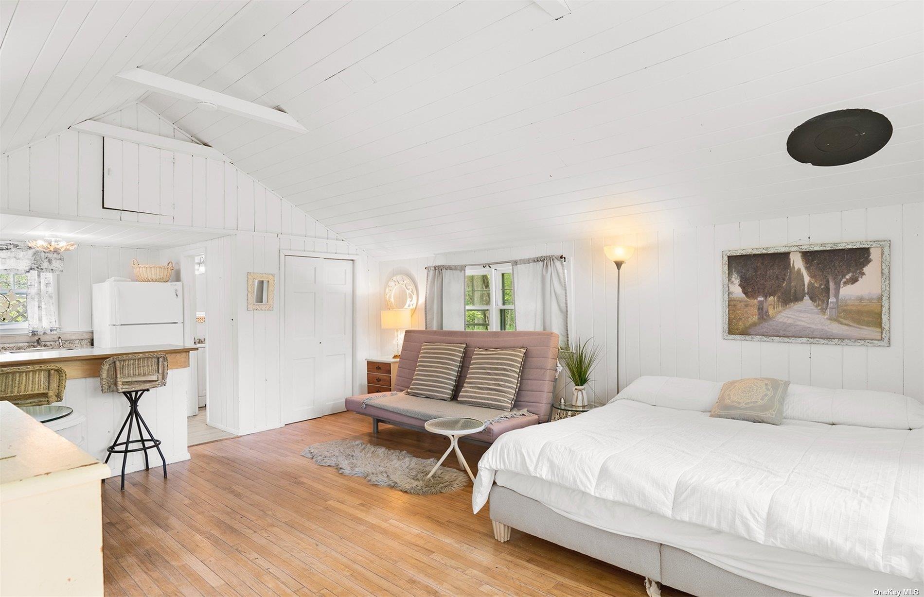 61 Lower 7 Ponds Road Water Mill, NY 11976 - Photo 42 of 43 a bedroom with a bed and wooden floor