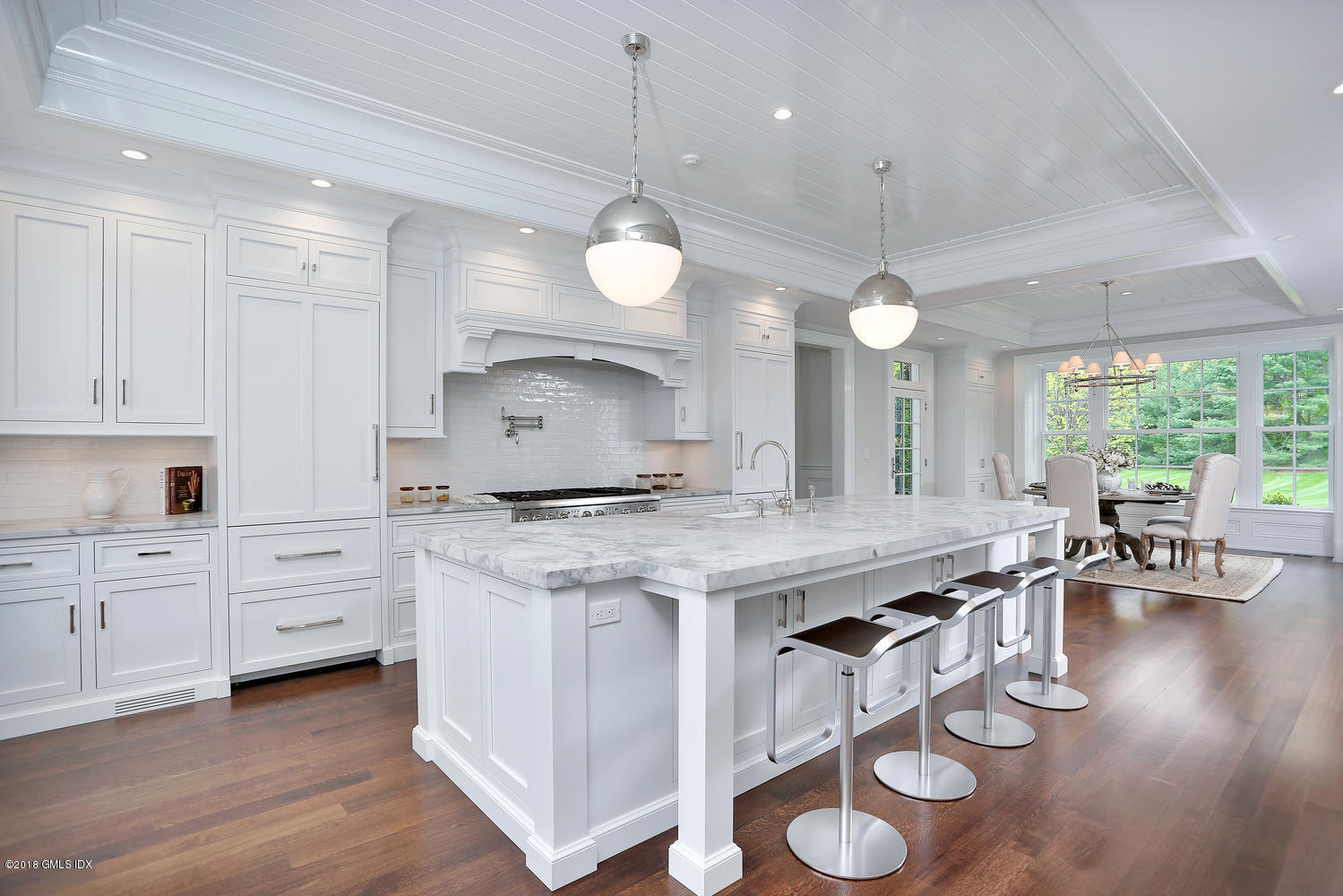 272 Round Hill Road Greenwich, CT 06831 - Photo 14 of 33 a large kitchen with kitchen island a stove a sink a dining table and chairs with wooden floor