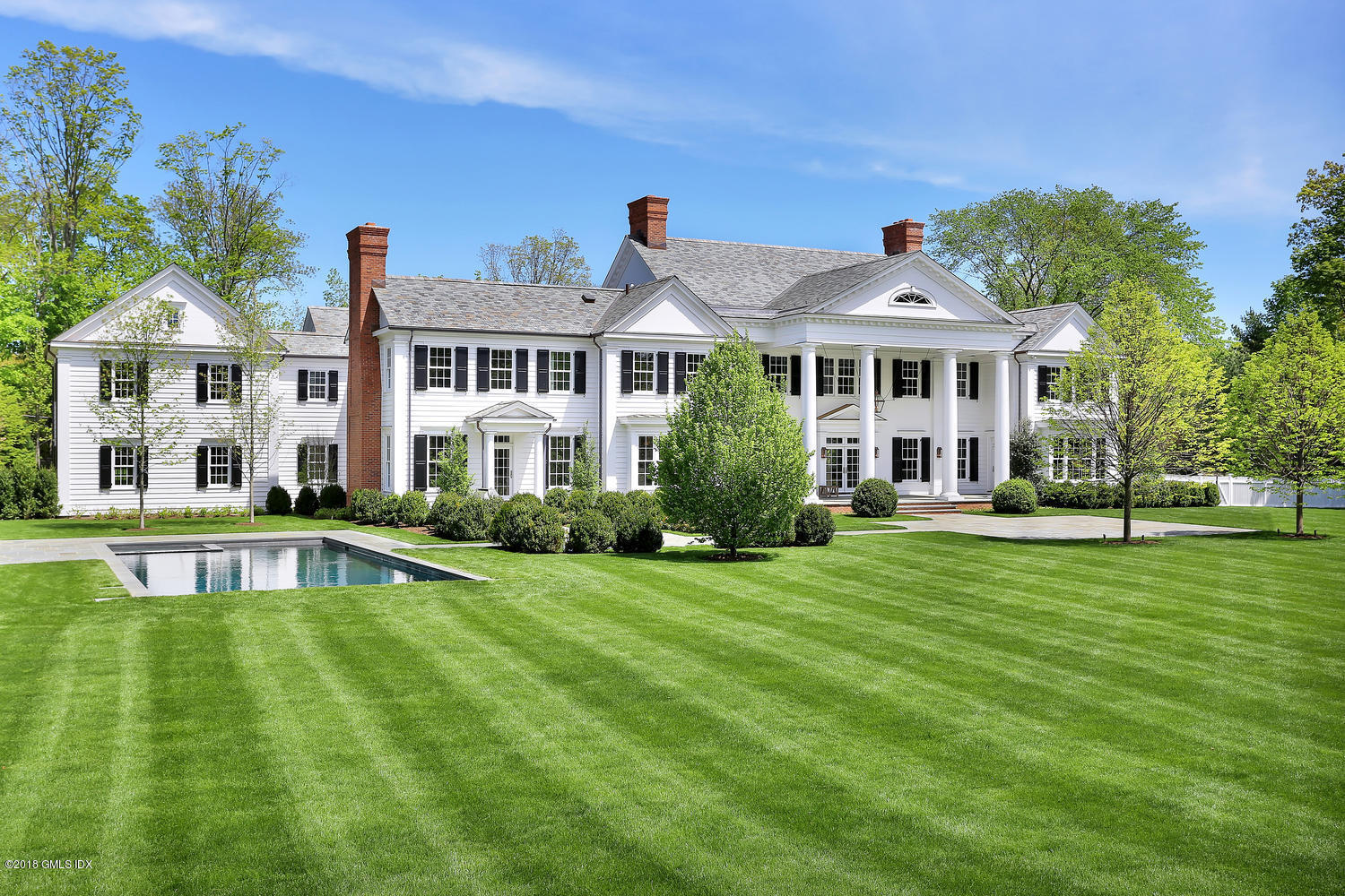 272 Round Hill Road Greenwich, CT 06831 - Photo 2 of 33 a front view of a house with a yard table and chairs