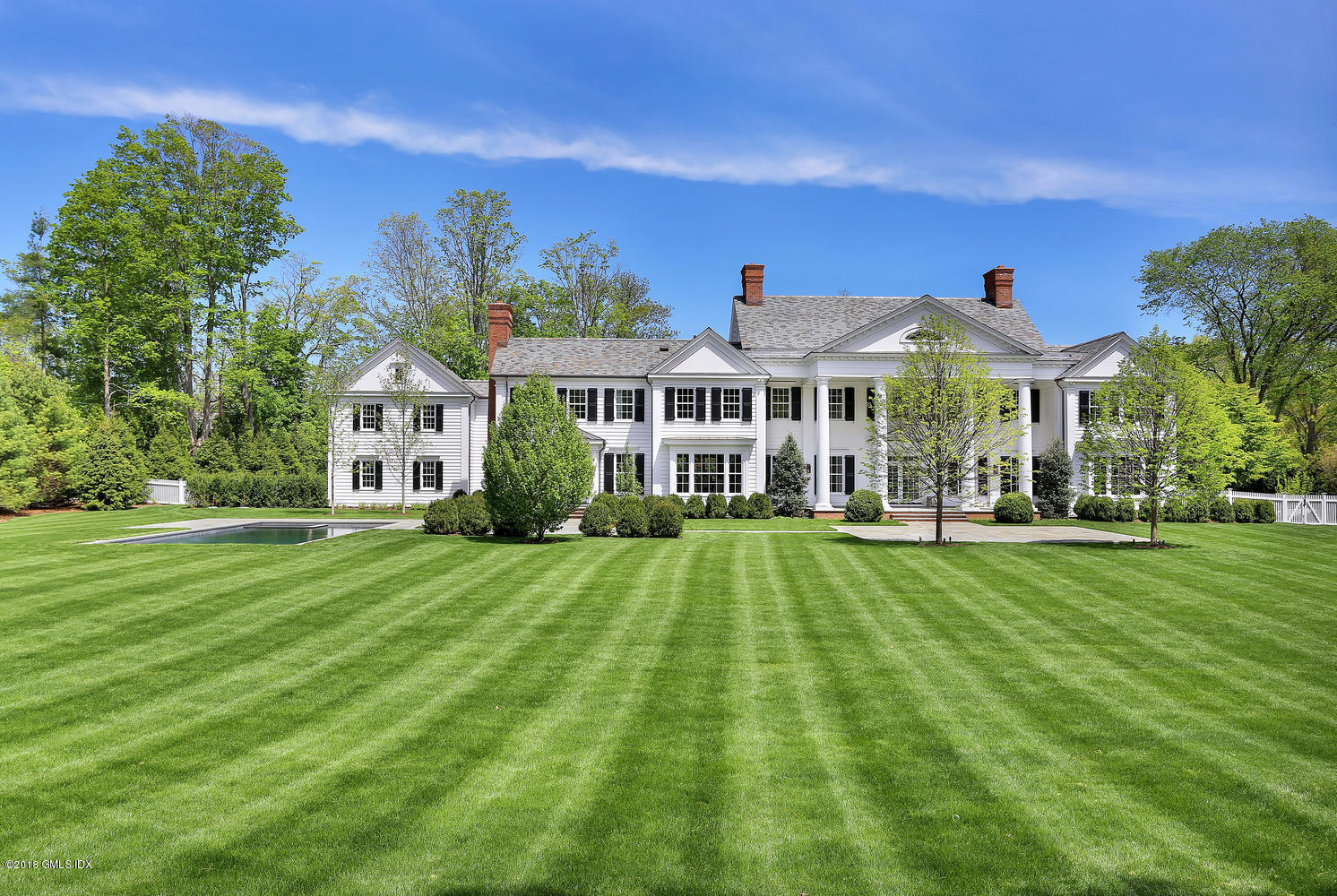 272 Round Hill Road Greenwich, CT 06831 - Photo 27 of 33 a front view of a house with a yard table and chairs
