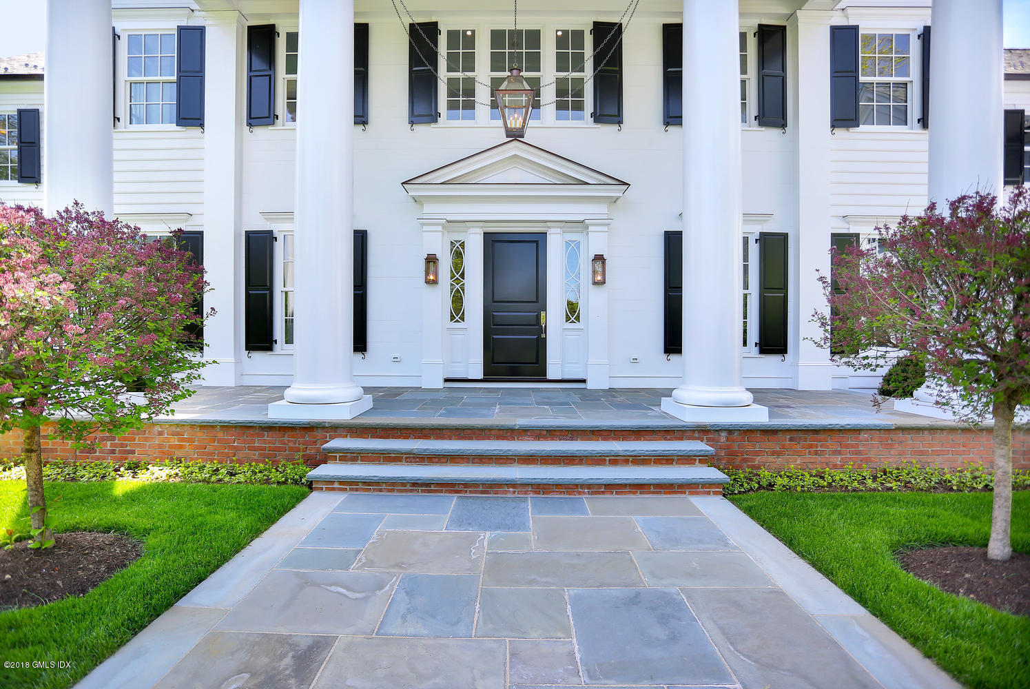 272 Round Hill Road Greenwich, CT 06831 - Photo 5 of 33 a front view of a house with garden and flowers