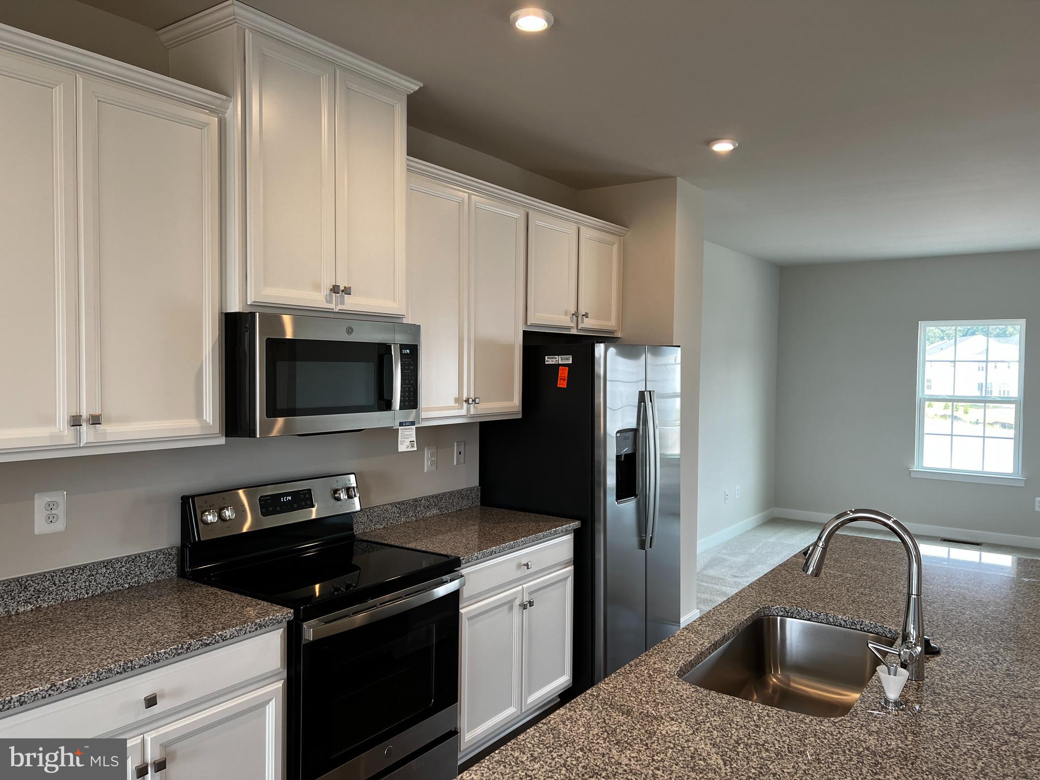913 Ericcson Lane Middletown, DE 19709 - Photo 14 of 50 a kitchen with stainless steel appliances granite countertop a sink stove and refrigerator