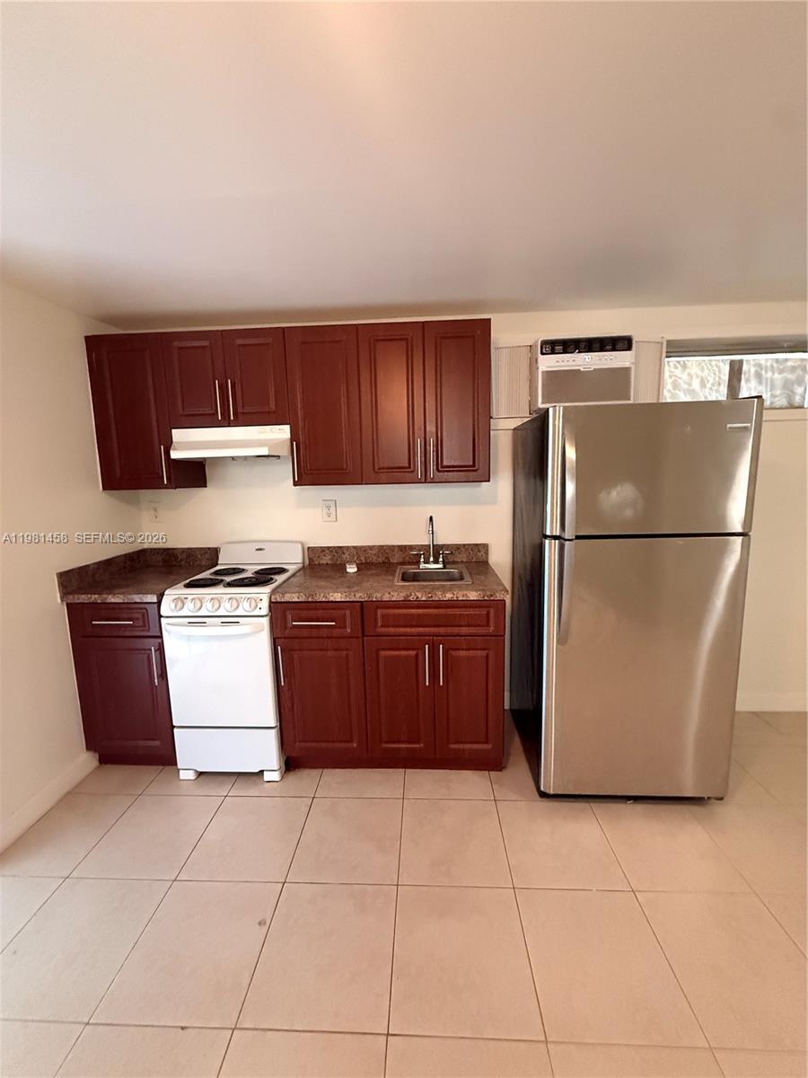 5230 Southwest 116th Avenue, Unit 3 Miami, FL 33165 - Photo 2 of 3 a kitchen with a refrigerator a stove top oven and a kitchen island