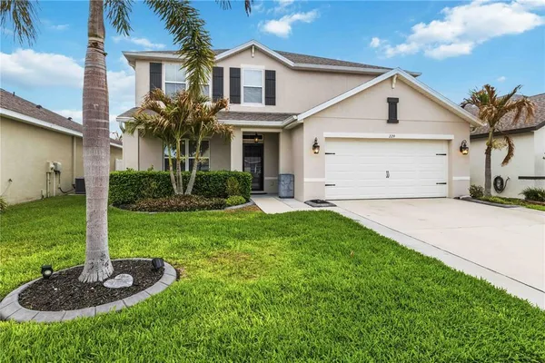 a front view of a house with a yard and garage