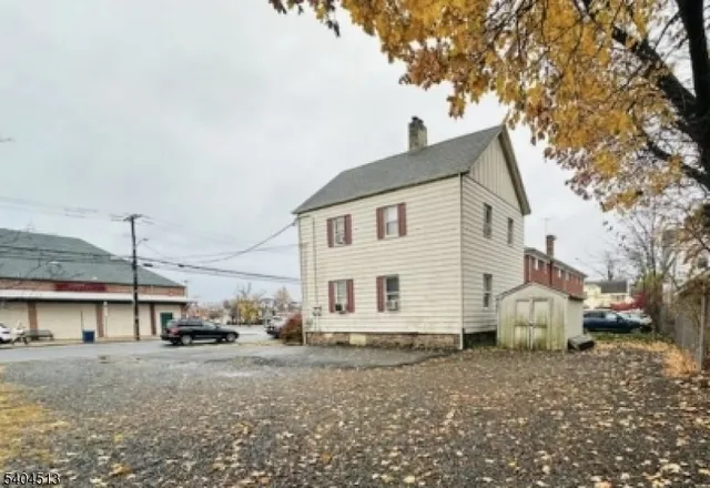 a view of a white house next to a road