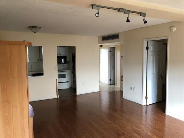 a view of a big room with wooden floor and windows