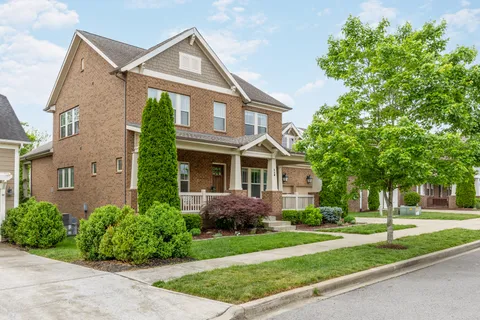 a front view of a house with a yard and trees