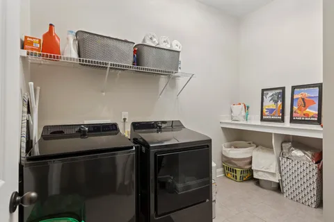 a utility room with dryer washer and shoe rack