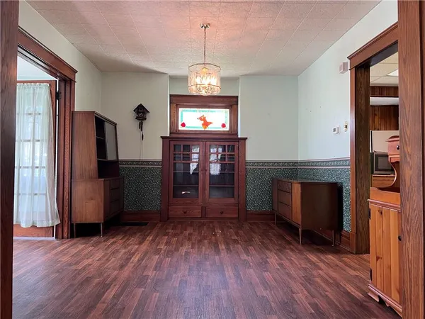 a view of a room with wooden floor refrigerator and windows