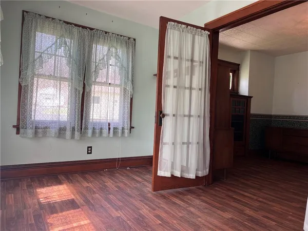 an empty room with wooden floor and a window
