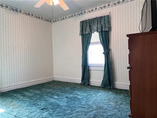 an empty room with a window and chandelier