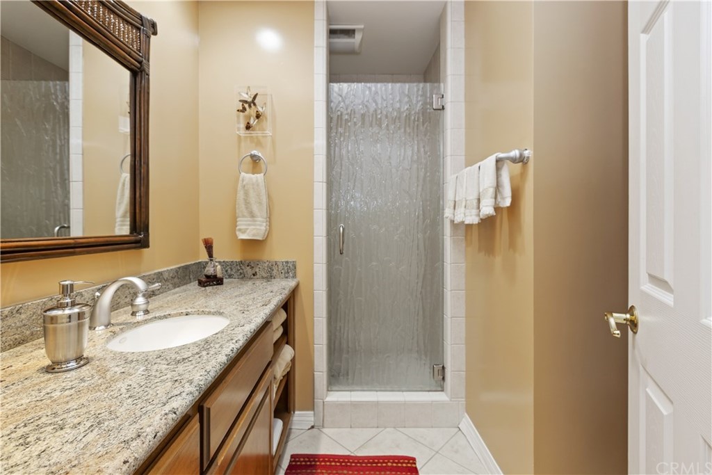 6272 Tecate Drive Riverside, CA 92506 - Photo 22 of 39 a bathroom with a granite countertop sink and a mirror