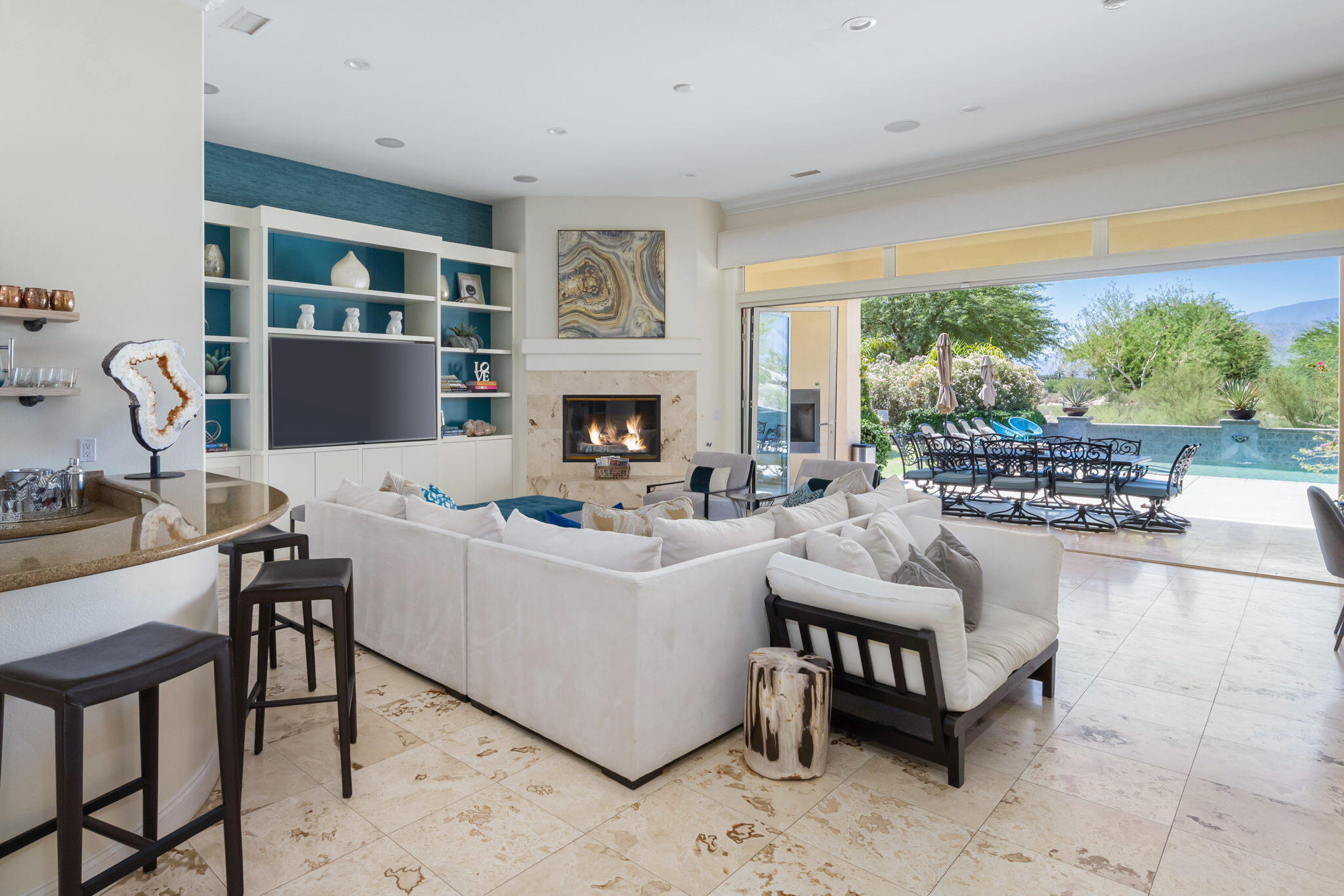 a living room with furniture a fireplace and a floor to ceiling window