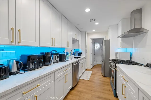 a view of kitchen with stainless steel appliances a refrigerator and a stove top oven