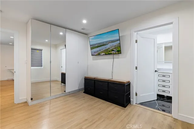 a view of an empty room with wooden floor and closet area