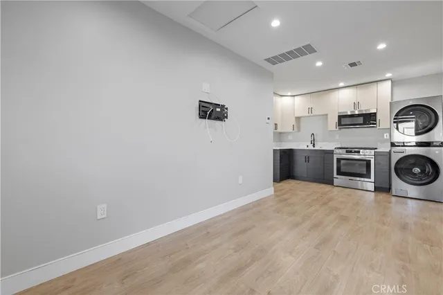 a view of a house with a wooden fence and a large tree