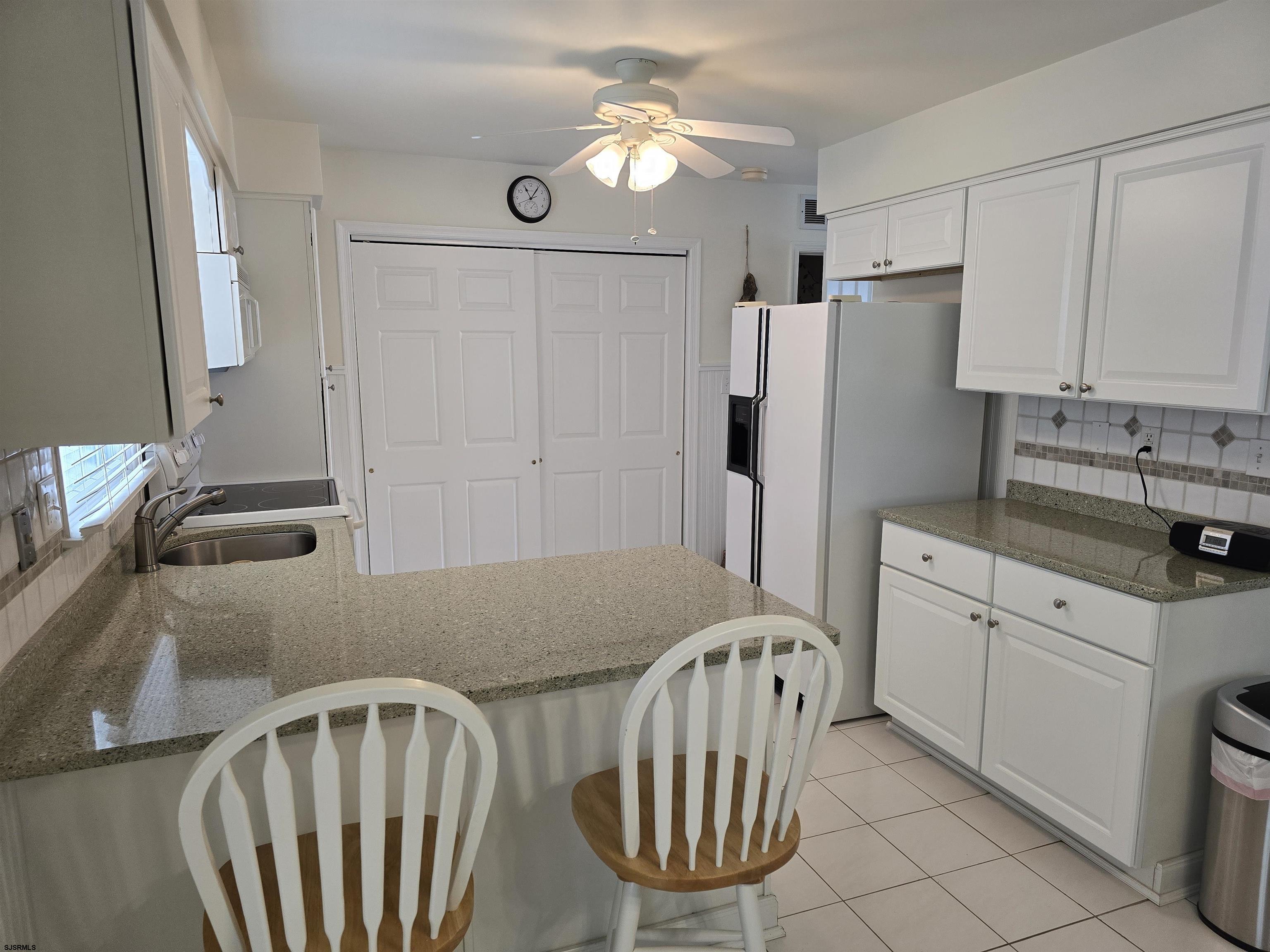 9 Gull Cove Brigantine, NJ 08203 - Photo 16 of 20 a kitchen with stainless steel appliances granite countertop a refrigerator a sink a stove with white cabinets