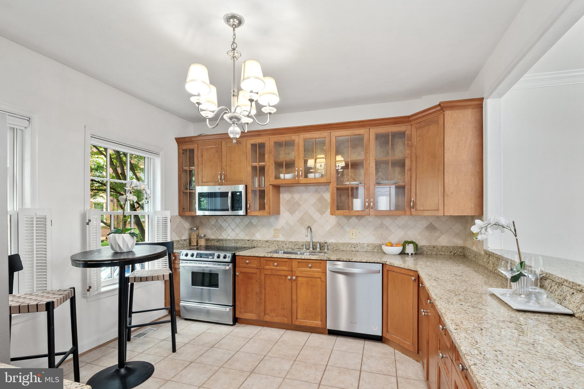 3729 Winfield Lane Northwest Washington, DC 20007 - Photo 9 of 22 a kitchen with a stove a sink a dining table and chairs