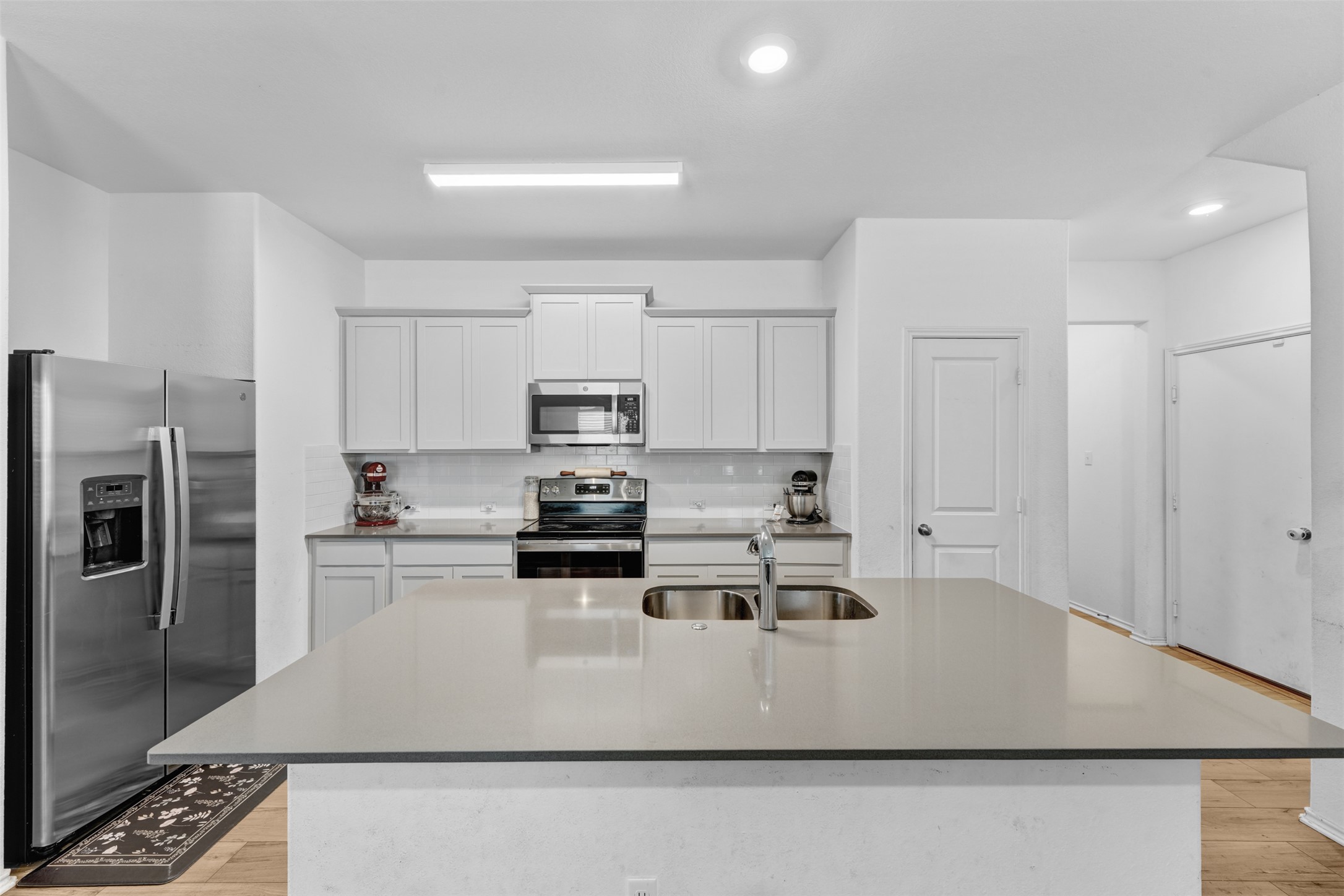 413 Perfect World Loop Jarrell, TX 76537 - Photo 10 of 39 A sleek island with an undermount sink anchors this contemporary kitchen, offering both practicality and modern appeal.