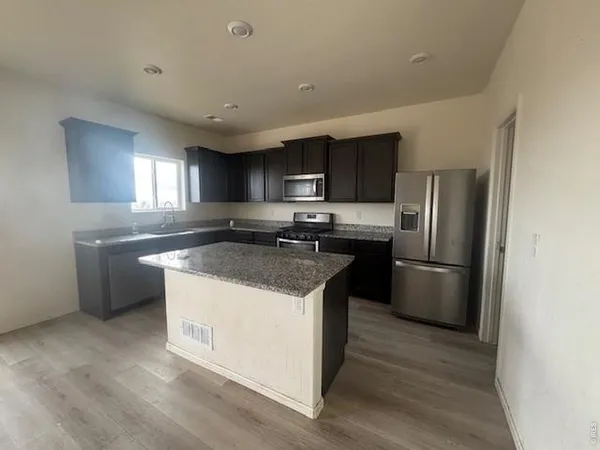 a kitchen with a sink a refrigerator a microwave a sink and cabinets