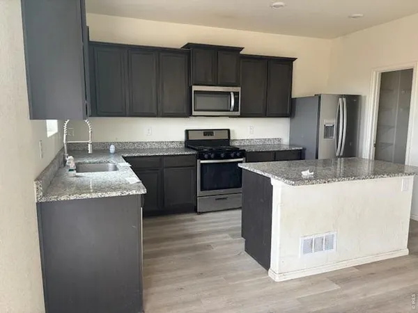 a kitchen with stainless steel appliances granite countertop wooden cabinets a stove top oven a sink and dishwasher