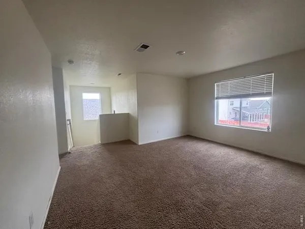 an empty room with windows and closet
