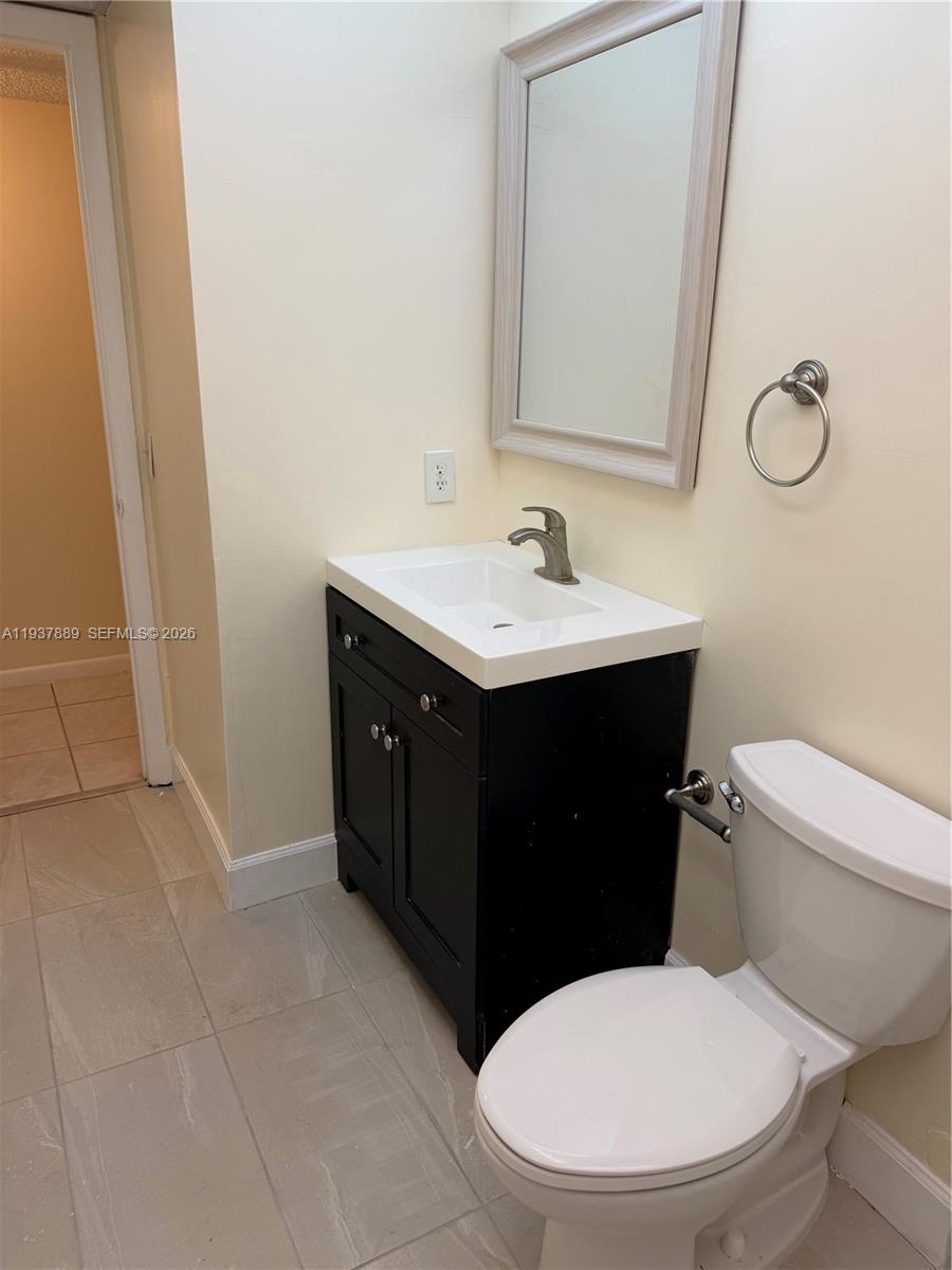 8500 Southwest 133rd Avenue Road, Unit 122 Miami, FL 33183 - Photo 12 of 22 a bathroom with a sink a toilet and mirror