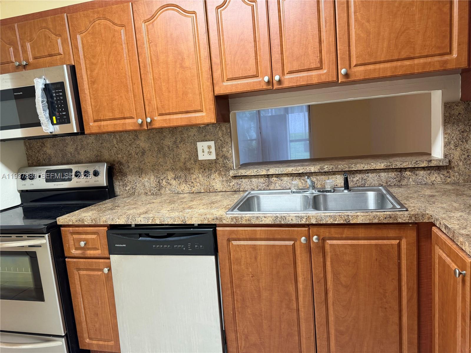 8500 Southwest 133rd Avenue Road, Unit 122 Miami, FL 33183 - Photo 18 of 22 a kitchen with granite countertop a sink and a stove