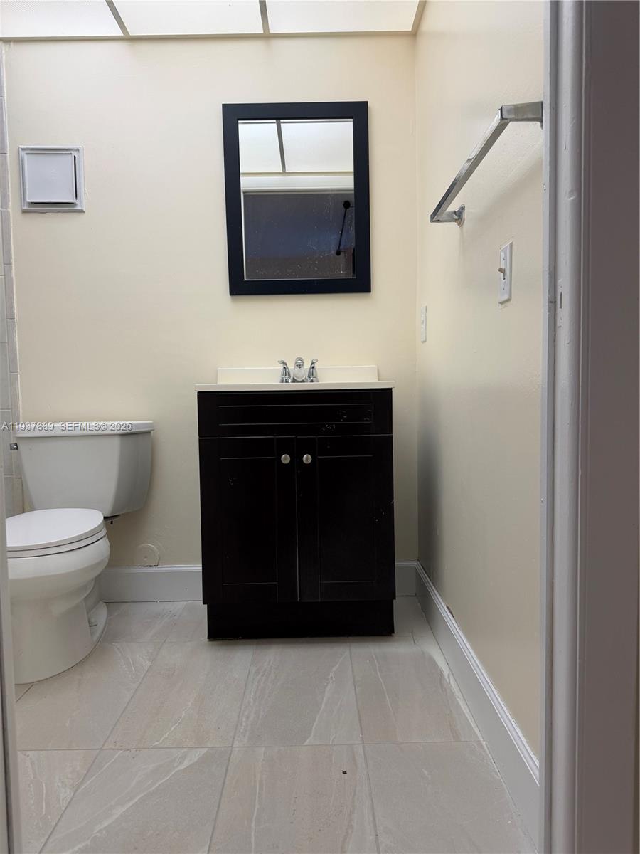 8500 Southwest 133rd Avenue Road, Unit 122 Miami, FL 33183 - Photo 9 of 22 a bathroom with a toilet a sink and mirror