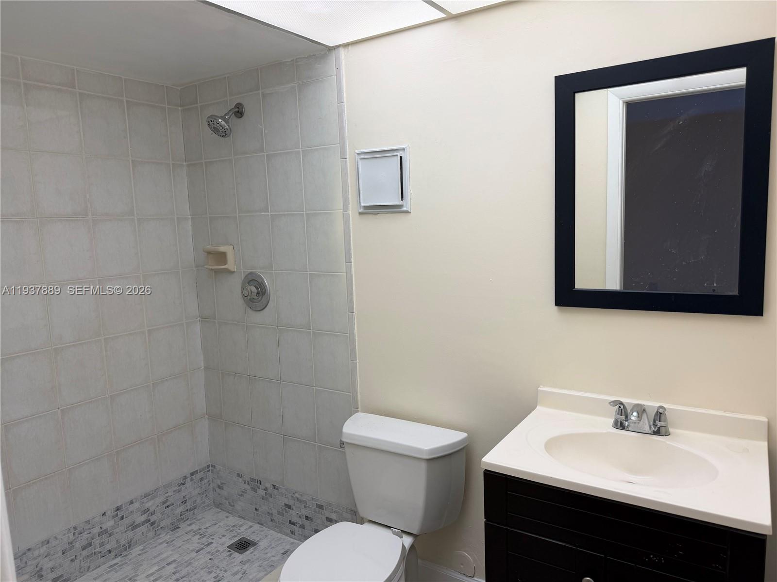 8500 Southwest 133rd Avenue Road, Unit 122 Miami, FL 33183 - Photo 10 of 22 a bathroom with a sink toilet a mirror and shower