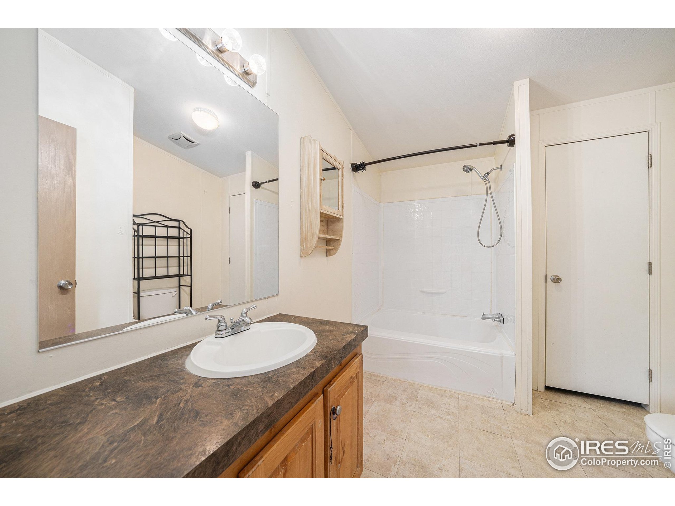 2500 East Harmony Road, Unit 191 Fort Collins, CO 80528 - Photo 11 of 22 a bathroom with a sink double vanity granite tub shower and a mirror