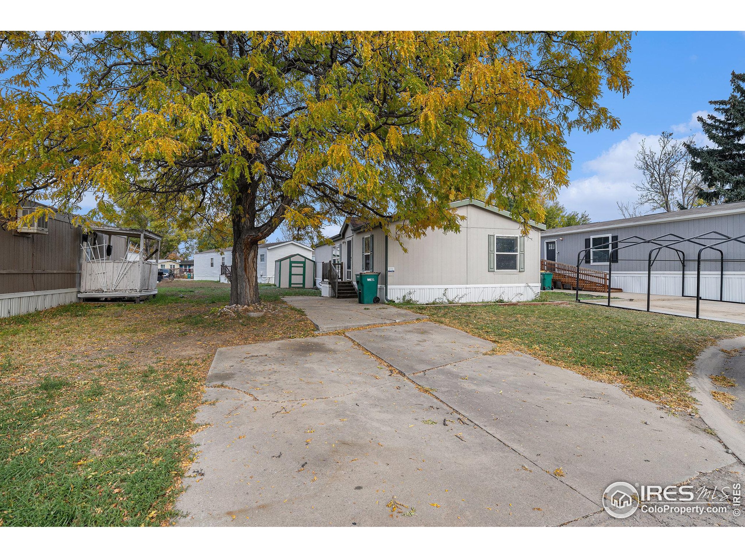 2500 East Harmony Road, Unit 191 Fort Collins, CO 80528 - Photo 2 of 22 a backyard of a house with large trees and outdoor seating