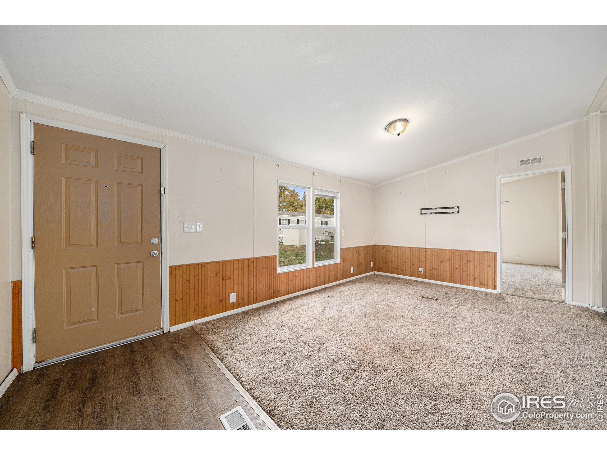 2500 East Harmony Road, Unit 191 Fort Collins, CO 80528 - Photo 8 of 22 a view of an empty room with wooden floor and a window