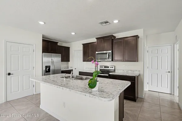 a kitchen with stainless steel appliances a sink and a refrigerator
