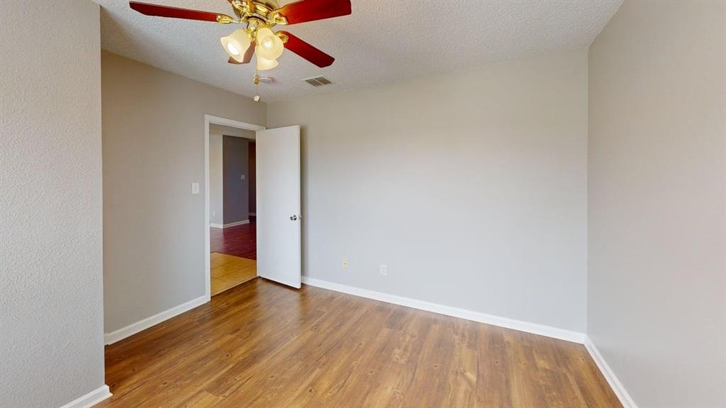 1505 Stewart Drive Rockwall, TX 75032 - Photo 12 of 20 a view of an empty room with a window and wooden floor