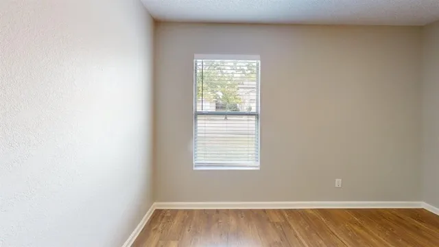 a view of a room with wooden floor and a window