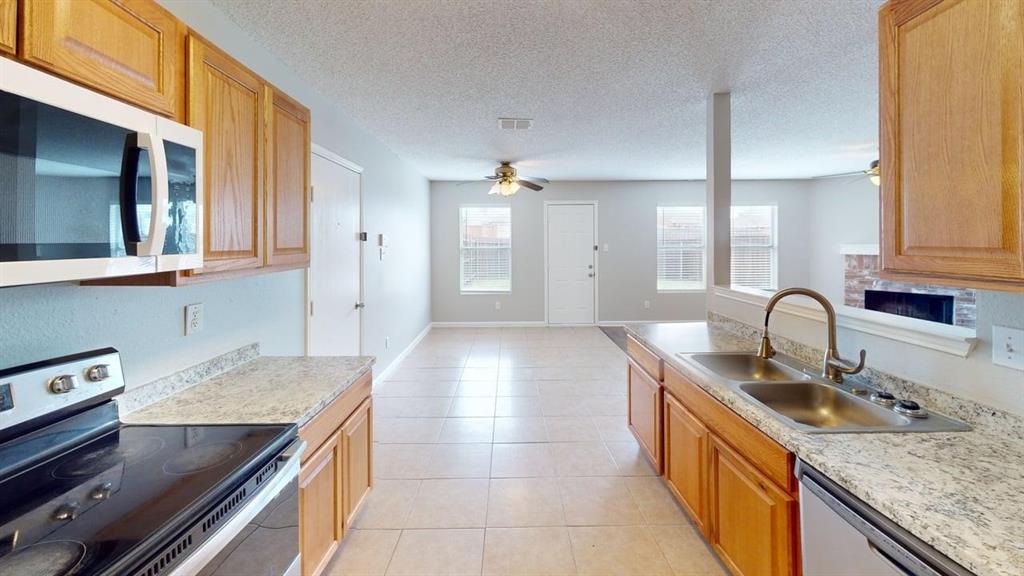 1505 Stewart Drive Rockwall, TX 75032 - Photo 5 of 20 a kitchen with stainless steel appliances granite countertop a sink a stove and a microwave oven