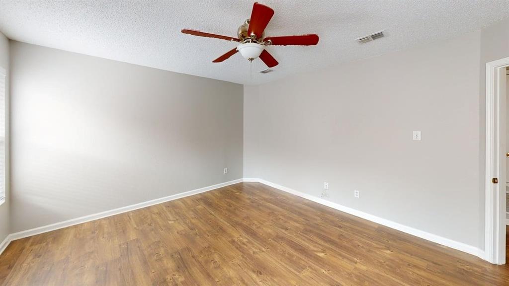 1505 Stewart Drive Rockwall, TX 75032 - Photo 9 of 20 a view of room with a ceiling fan and wooden floor