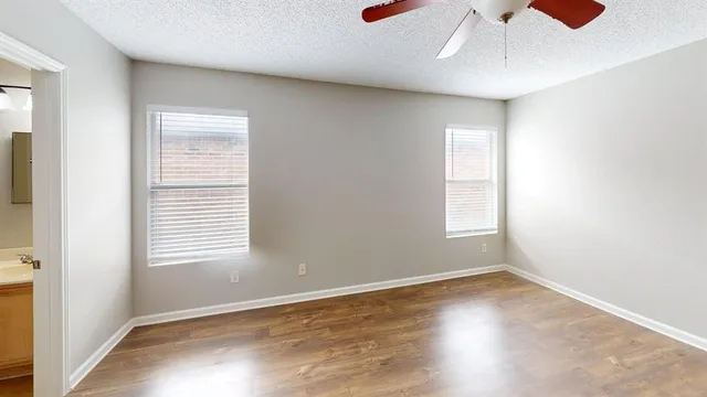 an empty room with a window and wooden floor