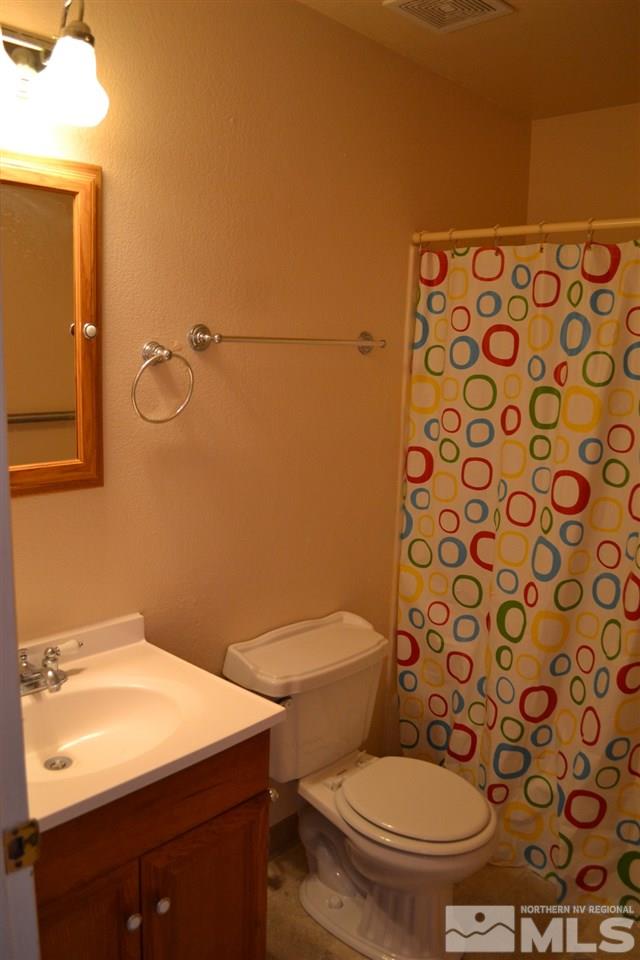 127 Ring Road Dayton, NV 89403 - Photo 11 of 24 a bathroom with a sink a toilet and shower curtain
