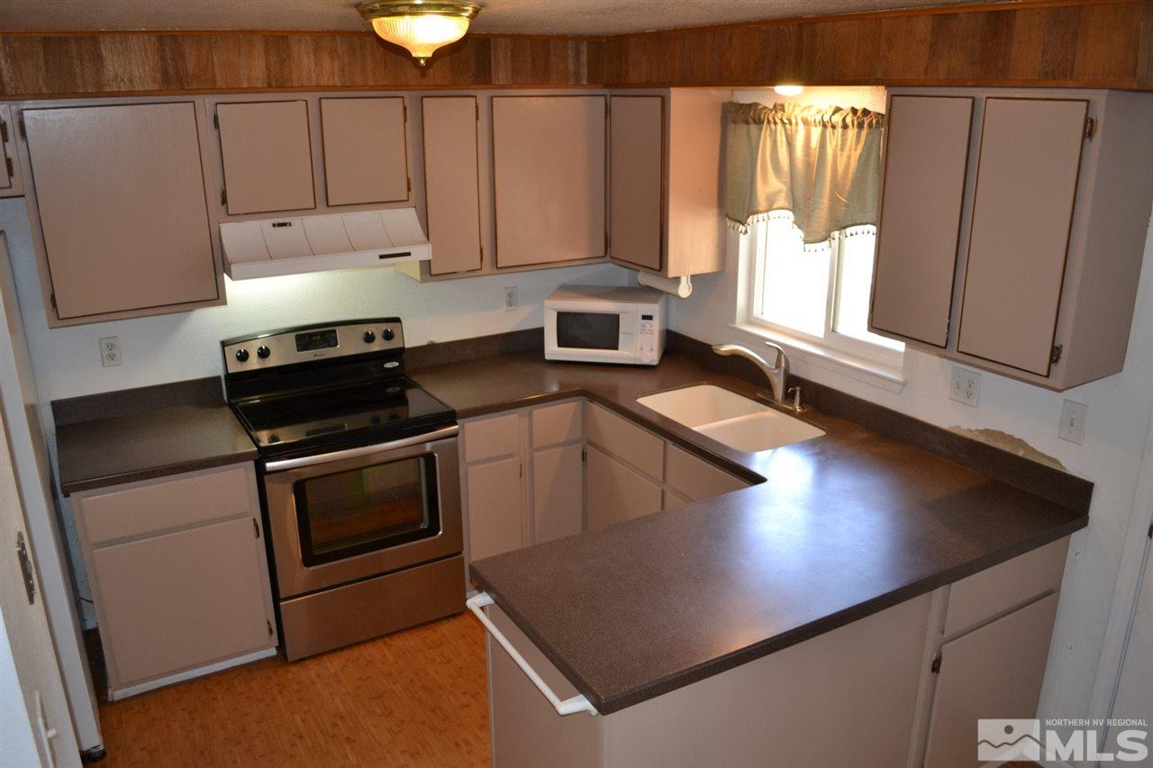 127 Ring Road Dayton, NV 89403 - Photo 8 of 24 a kitchen with stainless steel appliances granite countertop a sink a stove and a microwave