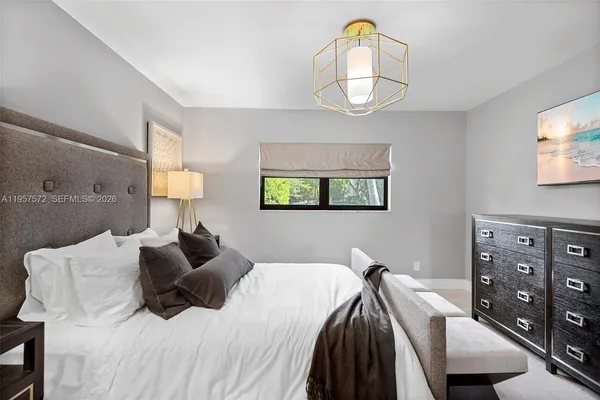 a bedroom with a bed a mirror and night stand