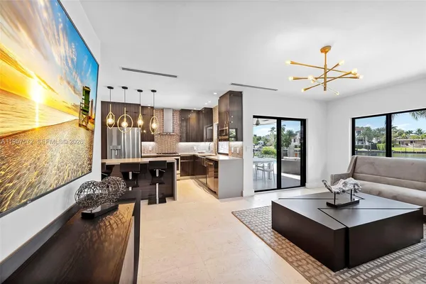 a living room with stainless steel appliances kitchen island granite countertop furniture and a large window