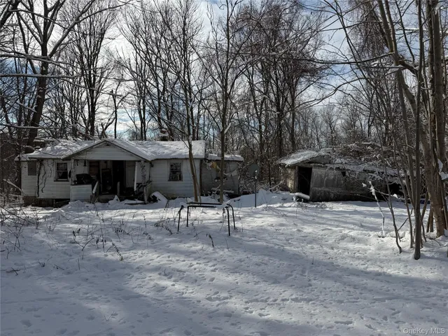 a view of a house with a yard and sitting area